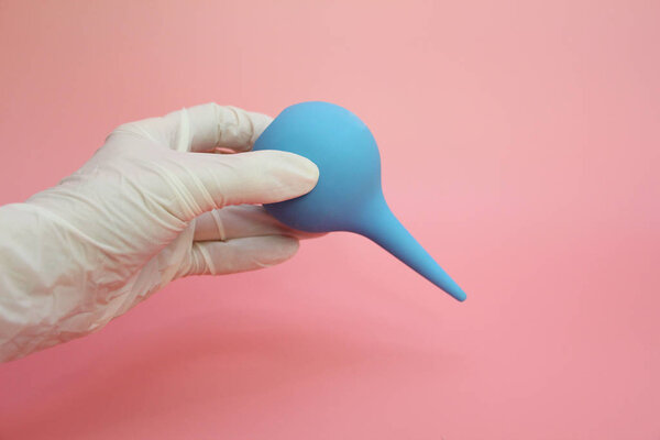 Blue syringe with a soft tip in the female hand of a doctor.