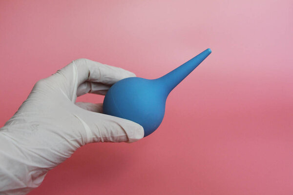 Blue syringe with a soft tip in the female hand of a doctor.