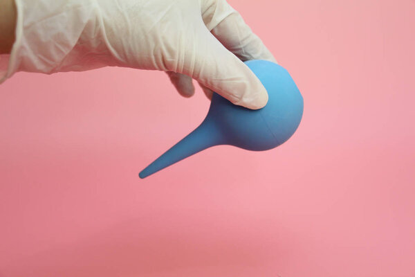 Blue syringe with a soft tip in the female hand of a doctor.