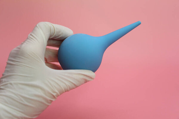 Blue syringe with a soft tip in the female hand of a doctor.