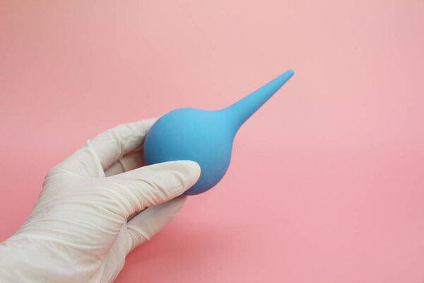 Blue syringe with a soft tip in the female hand of a doctor.