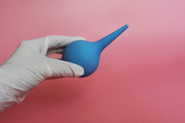 Blue syringe with a soft tip in the female hand of a doctor.