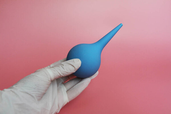 Blue syringe with a soft tip in the female hand of a doctor.