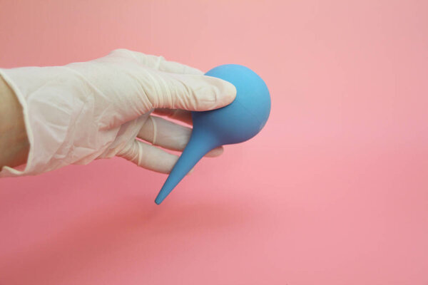 Blue syringe with a soft tip in the female hand of a doctor.