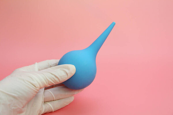 Blue syringe with a soft tip in the female hand of a doctor.