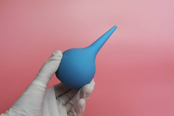 Blue syringe with a soft tip in the female hand of a doctor.