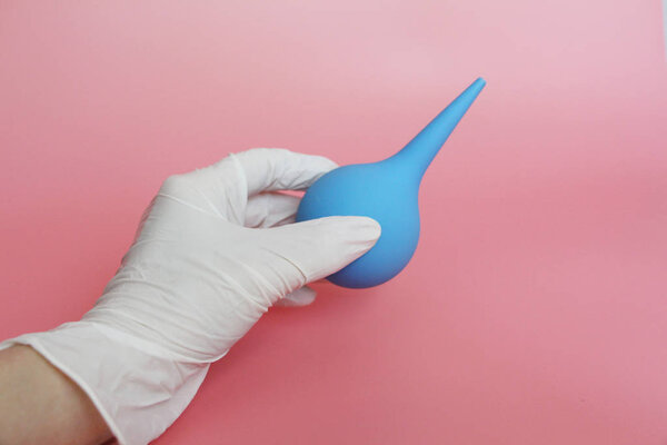 Blue syringe with a soft tip in the female hand of a doctor.
