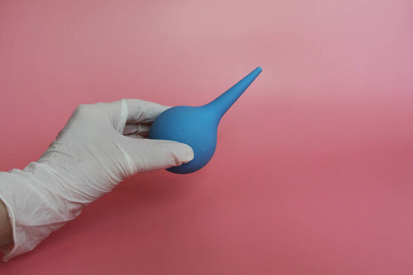 Blue syringe with a soft tip in the female hand of a doctor.