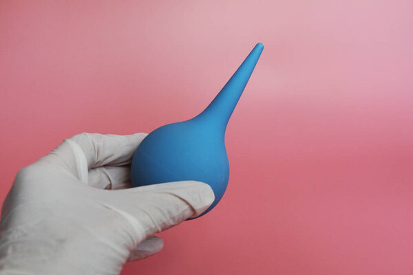 Blue syringe with a soft tip in the female hand of a doctor.