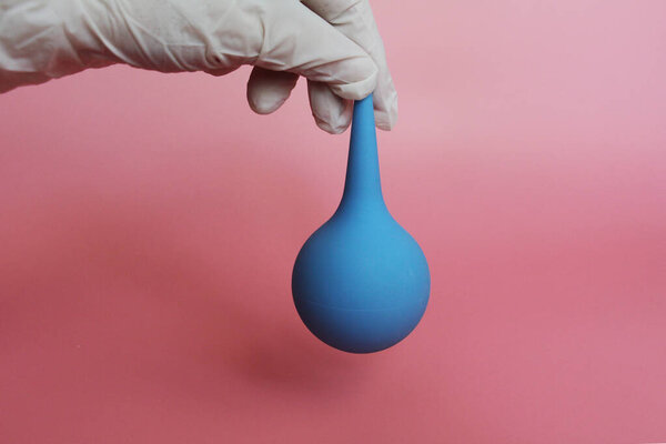 Blue syringe with a soft tip in the female hand of a doctor.