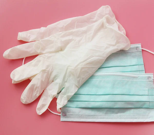 Two disposable medical masks and a pair of latex gloves.