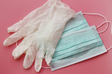 İki tek kullanımlık tıbbi maske ve bir çift lateks eldiven..