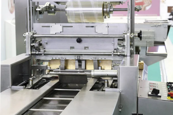 Automatic packing machine. Packing in a transparent cellophane film.