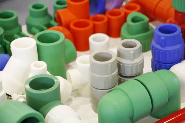 Many colored plugs, screws, valves, fittings, pipes, plastic adapters. — Stock Photo, Image