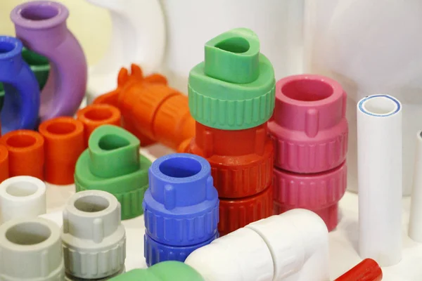 Many colored plugs, screws, valves, fittings, pipes, plastic adapters. — Stock Photo, Image