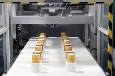 Tek kullanımlık plastik bardaklar üreten bir makinenin parçası..