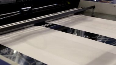 Video, plastik poşet üreten bir fabrikayı gösteriyor. Şaftlar dönüyor. Selofan şaftlar arasında hareket ediyor. Polietilen poşet üretimi için kullanılan bir makinenin parçaları.
