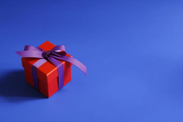 Όμορφο Κόκκινο Κουτί Δώρου Ένα Μωβ Τόξο Μπλε Φόντο Κουτί — Φωτογραφία Αρχείου