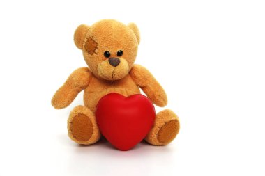 Beyaz arka planda kırmızı kalbi olan bir oyuncak ayı..