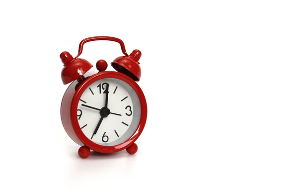 एक सफेद पृष्ठभूमि पर लाल घड़ी। घड़ी 7 घंटे दिखाती है . — स्टॉक फ़ोटो, इमेज