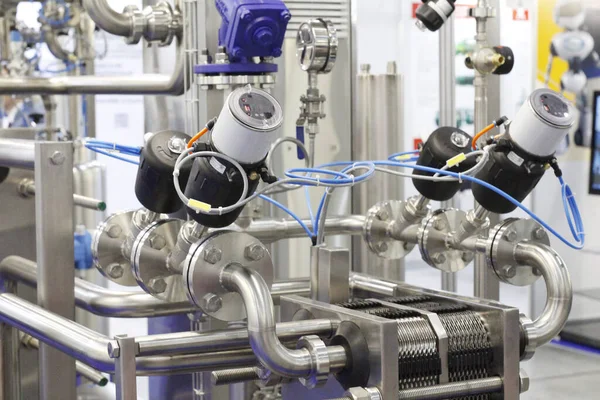 Stainless steel pipes in a food factory. Stainless pipe fittings. Tubular heat exchangers. Food pumps. A fragment of a dairy plant.