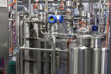 Moscow, RF, 02.20.2020: Installation of centrifugal separation and pasteurization. Globe valves in a dairy factory. Stainless steel pumps.