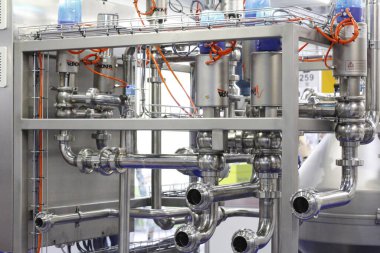 Moscow, RF, 02.20.2020: Installation of centrifugal separation and pasteurization. Globe valves in a dairy factory. Stainless steel pumps.