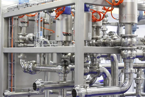 Moscow, RF, 02.20.2020: Installation of centrifugal separation and pasteurization. Globe valves in a dairy factory. Stainless steel pumps.
