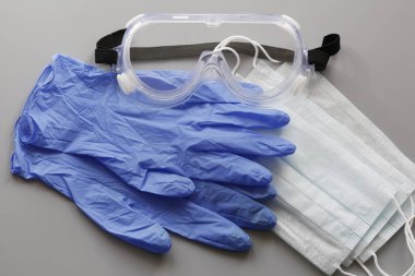 COVID-19. Coronavirus. Coronavirus enfeksiyonu. Tek kullanımlık birkaç yüz maskesi ve bir çift lateks eldiven. Gereken tek kullanımlık tıbbi malzemeler. Yüzün ve ellerin tıbbi koruması.