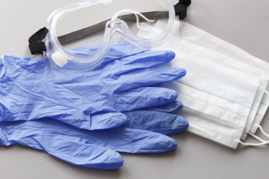 COVID-19. Coronavirus. Coronavirus enfeksiyonu. Tek kullanımlık birkaç yüz maskesi ve bir çift lateks eldiven. Gereken tek kullanımlık tıbbi malzemeler. Yüzün ve ellerin tıbbi koruması.