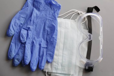 COVID-19. Coronavirus. Coronavirus enfeksiyonu. Tek kullanımlık birkaç yüz maskesi ve bir çift lateks eldiven. Gereken tek kullanımlık tıbbi malzemeler. Yüzün ve ellerin tıbbi koruması.