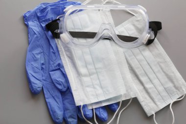 COVID-19. Coronavirus. Coronavirus enfeksiyonu. Tek kullanımlık birkaç yüz maskesi ve bir çift lateks eldiven. Gereken tek kullanımlık tıbbi malzemeler. Yüzün ve ellerin tıbbi koruması.