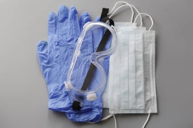 COVID-19. Coronavirus. Coronavirus enfeksiyonu. Tek kullanımlık birkaç yüz maskesi ve bir çift lateks eldiven. Gereken tek kullanımlık tıbbi malzemeler. Yüzün ve ellerin tıbbi koruması.