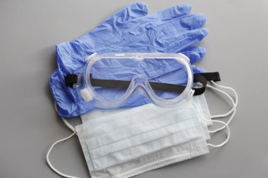 COVID-19. Coronavirus. Coronavirus enfeksiyonu. Tek kullanımlık birkaç yüz maskesi ve bir çift lateks eldiven. Gereken tek kullanımlık tıbbi malzemeler. Yüzün ve ellerin tıbbi koruması.