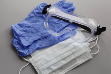 COVID-19. Coronavirus. Coronavirus enfeksiyonu. Tek kullanımlık birkaç yüz maskesi ve bir çift lateks eldiven. Gereken tek kullanımlık tıbbi malzemeler. Yüzün ve ellerin tıbbi koruması.