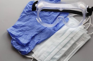 COVID-19. Coronavirus. Coronavirus enfeksiyonu. Tek kullanımlık birkaç yüz maskesi ve bir çift lateks eldiven. Gereken tek kullanımlık tıbbi malzemeler. Yüzün ve ellerin tıbbi koruması.