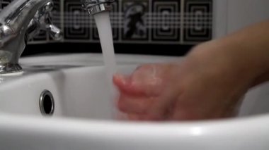 El yıkama. Suyun altında ellerini yıka. Hijyen konsepti ve virüs önleme. Kadın ellerine yakın çekim. Banyoda el yıkama. COVID-19. Coronavirus. Coronavirüs enfeksiyonu.