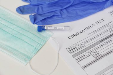 Coronavirus laboratuvar testi. Kavram. Masanın üzerinde test tüpü, lateks tıbbi eldivenler, yüz maskesi ve testler için izin var. Kimse yok..