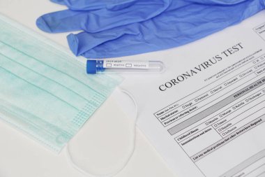 Coronavirus laboratuvar testi. Kavram. Masanın üzerinde test tüpü, lateks tıbbi eldivenler, yüz maskesi ve testler için izin var. Kimse yok..
