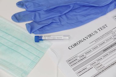 Coronavirus laboratuvar testi. Kavram. Masanın üzerinde test tüpü, lateks tıbbi eldivenler, yüz maskesi ve testler için izin var. Kimse yok..