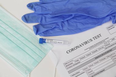 Coronavirus laboratuvar testi. Kavram. Masanın üzerinde test tüpü, lateks tıbbi eldivenler, yüz maskesi ve testler için izin var. Kimse yok..