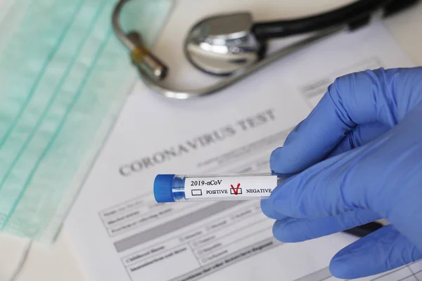 Kavramsal fotoğrafçılık, koronavirüs testi. Elinde hastanın numunesinin olduğu bir test tüpü var. Analizin sonucu olumsuzdur. Tadı Coronavirus COVID-19 için negatif çıktı..