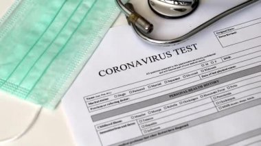 Coronavirus 'un belirlenmesi için laboratuvar testi. Kavram. Hasta analiz için onay formunu doldurur. Test tüpünde pozitif ve negatif olduğu yazıyor. Evet. Masada testleri yaptırmak için rıza var..