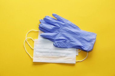 COVID-19. Coronavirus. Coronavirus enfeksiyonu. Tek kullanımlık birkaç yüz maskesi ve bir çift lateks eldiven. Gereken tek kullanımlık tıbbi malzemeler. Yüzün ve ellerin tıbbi koruması.