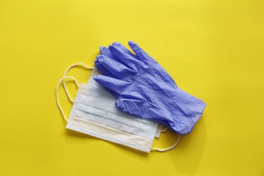 COVID-19. Coronavirus. Coronavirus enfeksiyonu. Tek kullanımlık birkaç yüz maskesi ve bir çift lateks eldiven. Gereken tek kullanımlık tıbbi malzemeler. Yüzün ve ellerin tıbbi koruması.