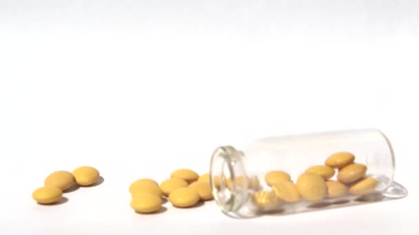 Žluté pilulky vytékají ze skleněné láhve. Koncept medicíny a zdraví. Tablety se nalévají ze zkumavky.