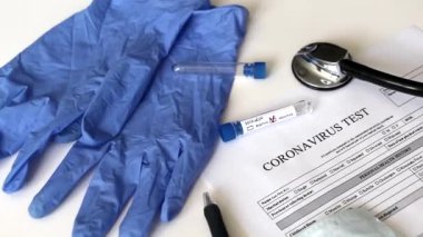 Videoda bir tıp doktorunun masası var. Masada Coronavirus analizi için bir test var. Negatif koronavirüs testi. İnsanları tıbbi test etme kavramı. 