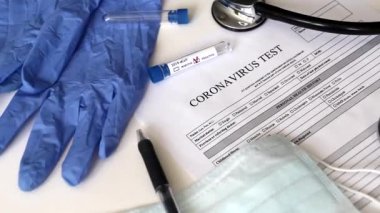 Videoda bir tıp doktorunun masası var. Masada Coronavirus analizi için bir test var. Negatif koronavirüs testi. İnsanları tıbbi test etme kavramı. 