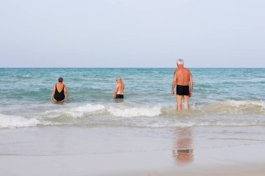 Yaşlı insanlar denize giriyorlar. Kumsaldaki yaşlı adamlar. Mutlu emeklilik. Yaşlıların geri kalanı sahilde. Seyahat eden yaşlılar.