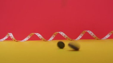 Video düğmelerin nasıl üste düştüğünü gösteriyor. Arka planda bir metre şeridi var, santimetre..